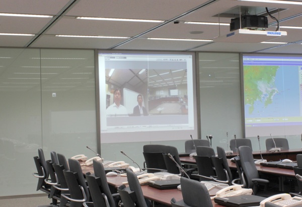 緊急対策本部となる本社内の会議室に映し出されたV-CUBE ミーティングの画面。 緊急対策本部となる本社内の会議室に映し出されたV-CUBE ミーティングの画面。