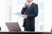 イベント代行会社の見積もり書を前に検討するビジネスマン
