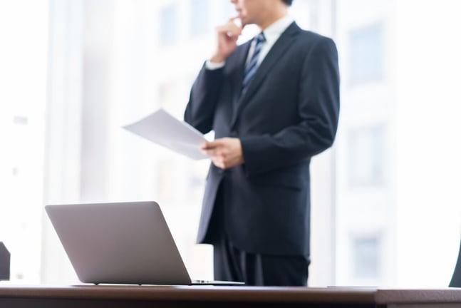 イベント代行会社の見積もり書を前に検討するビジネスマン