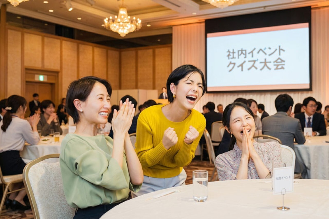 チーム対抗のクイズ大会で、社員が主役としてチーム一体となって参加している様子