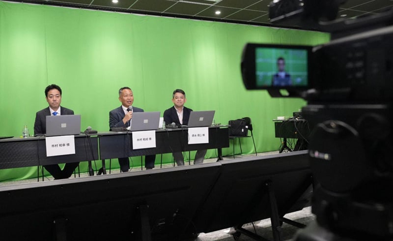 複数展開する事業の現状や戦略について、投資家により理解を深めてもらう場として、事業説明会を実施。  各事業ユニットのリーダーが行う事業説明パートは、正確かつ分かりやすく説明を行うべく、事前にスタジオで収録した録画映像をライブ配信した。リアルタイムに対応したい質疑応答パートは、リーダーがスタジオもしくは遠隔から参加し、合成技術により登壇者全員が同じ環境にいるような画面構成で配信した。  事前収録とZoomでのライブ配信は、ブイキューブの専用スタジオ「PLATINUM STUDIO」から行い、配信機材やネットワークが完備された環境から安定的に配信。複数日程にわたる事前収録も豊富なスタジオ数で対応でき、また、ライブ配信時も十数名を収容できる広いスタジオで滞りない配信を実現できた。