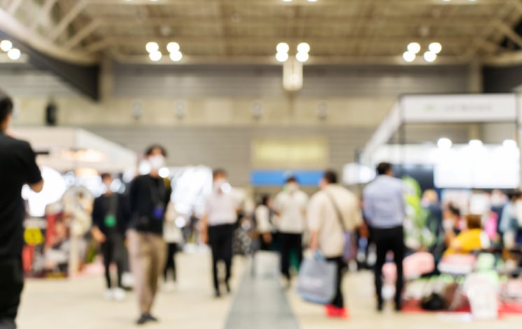 展示会場で企業ブースを見て回る来場者が行き交うイベント風景