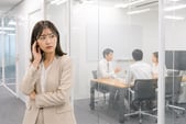 オフィスで会議室の外に話し声が漏れている様子と、それを気にする従業員のイメージ