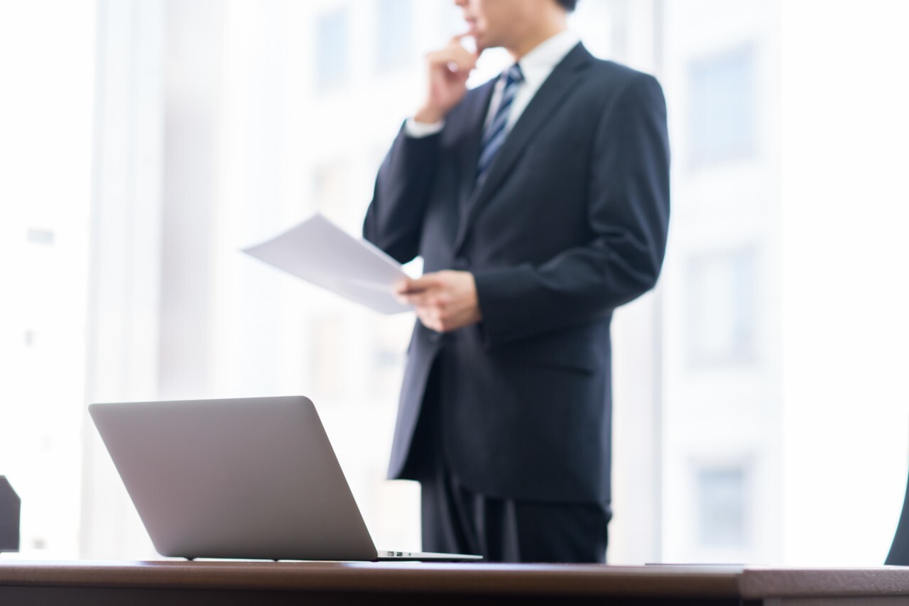 イベント代行会社の見積もり書を前に検討するビジネスマン