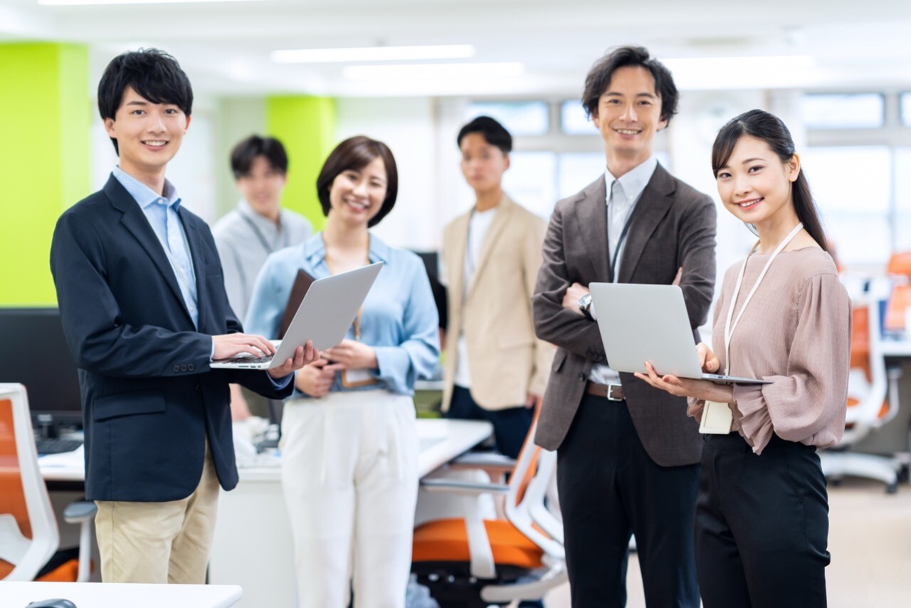 企業の採用ブランディングと差別化をテーマにした、活気ある採用イベント会場で多様なビジネスパーソンが交流する写真