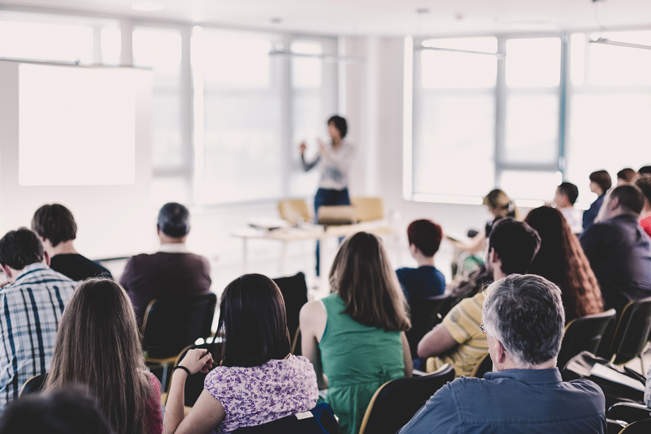 カンファレンス会場で講演を聴講する参加者たちの様子
